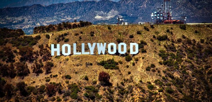 a sign on a hill with Hollywood Sign in the background