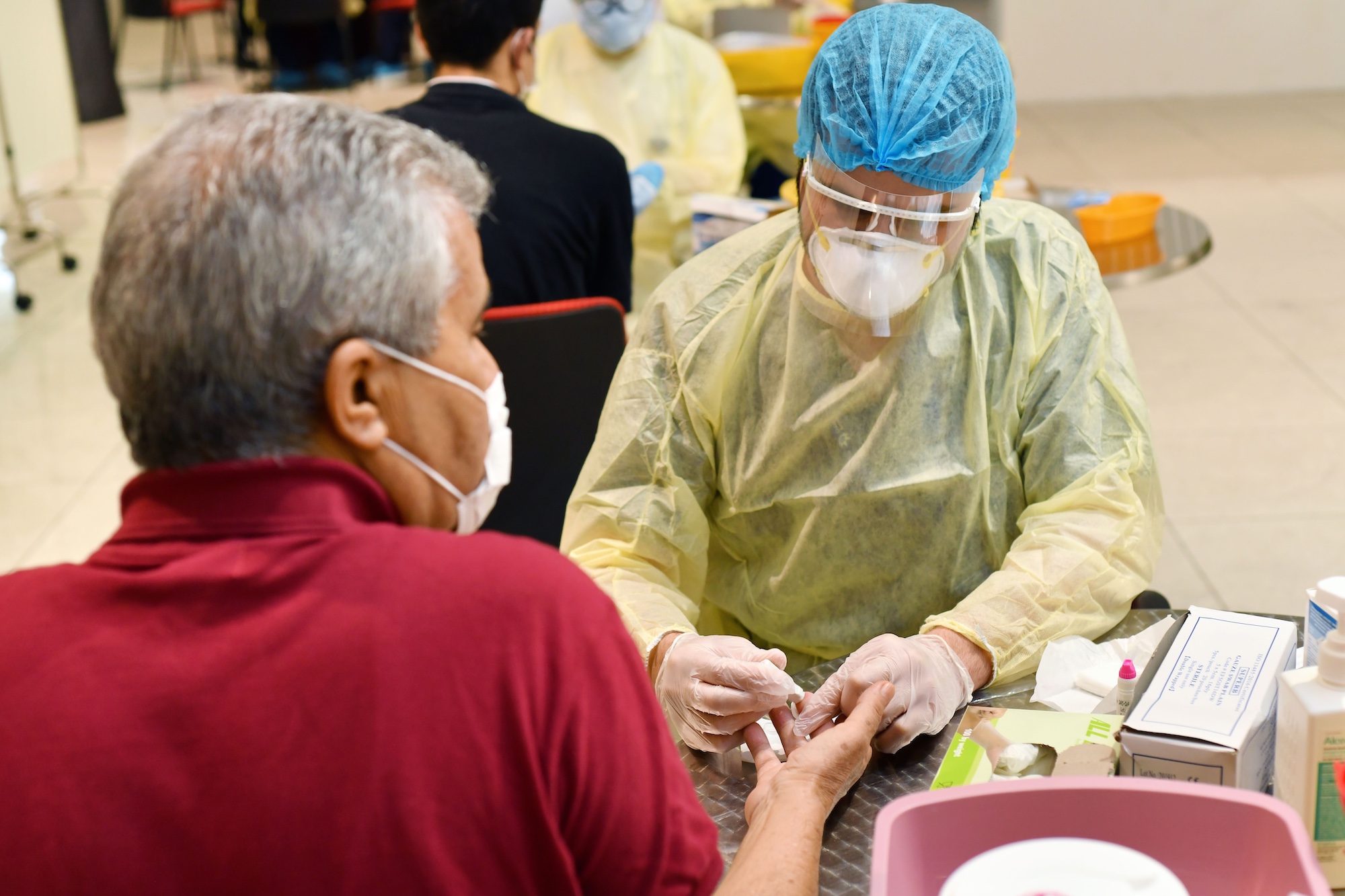 a man wearing a mask and gloves while another man wearing a mask