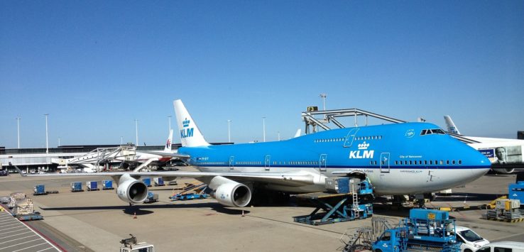 a blue and white airplane at an airport