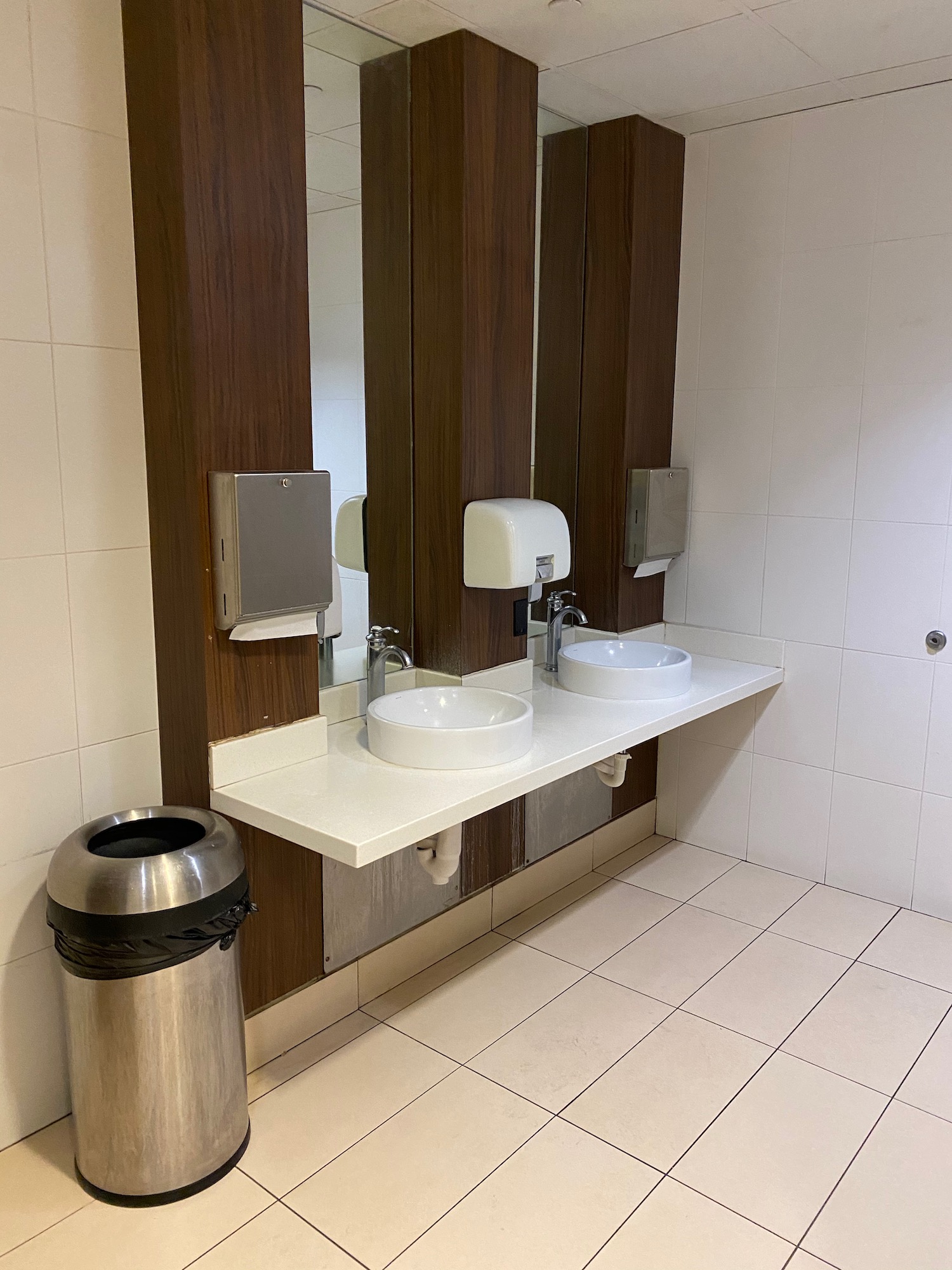 a bathroom with sinks and a trash can