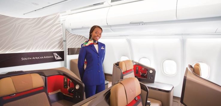 a woman in a blue uniform standing in a plane