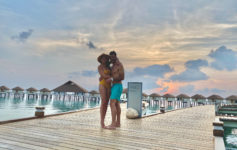 a man and woman hugging on a dock