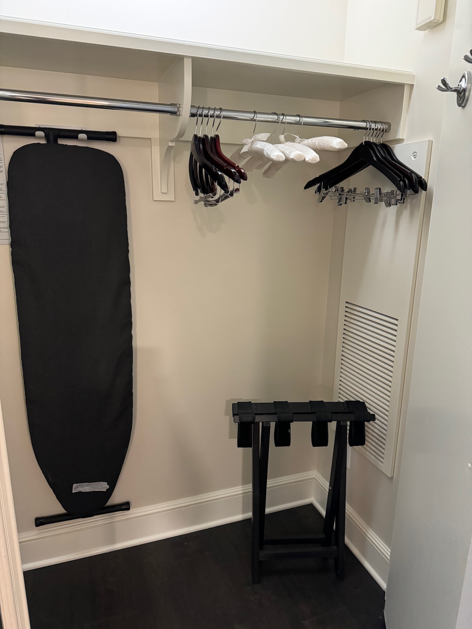 a closet with swingers and a ironing board