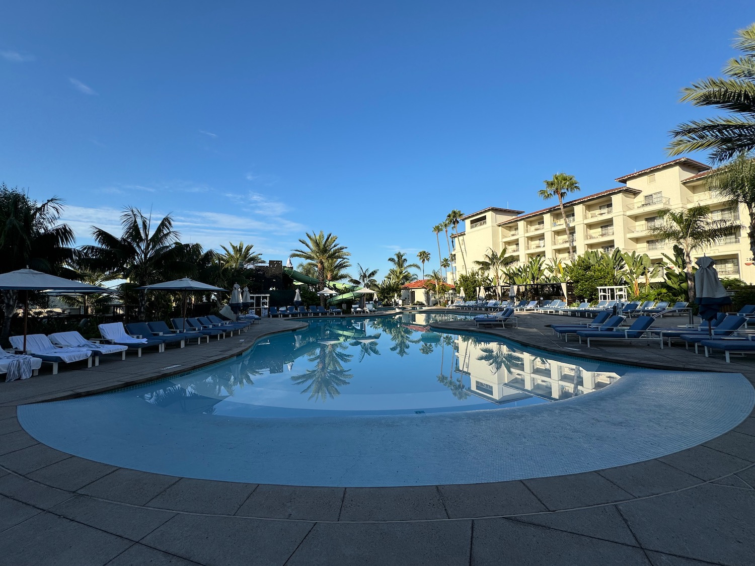 a pool with lounge chairs and a building in the background