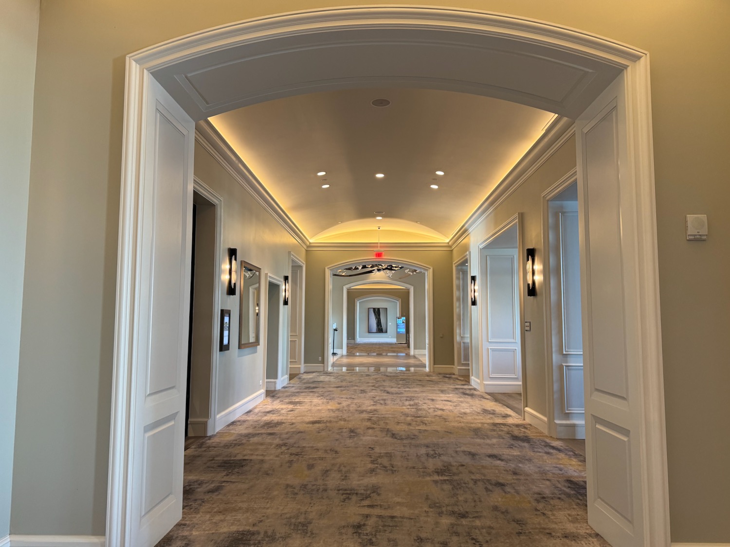 a hallway with white walls and a light fixture