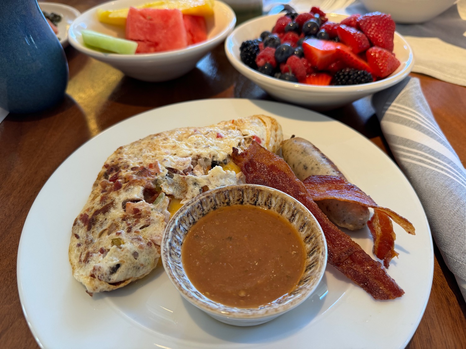 a plate of food with fruit and a bowl of sauce