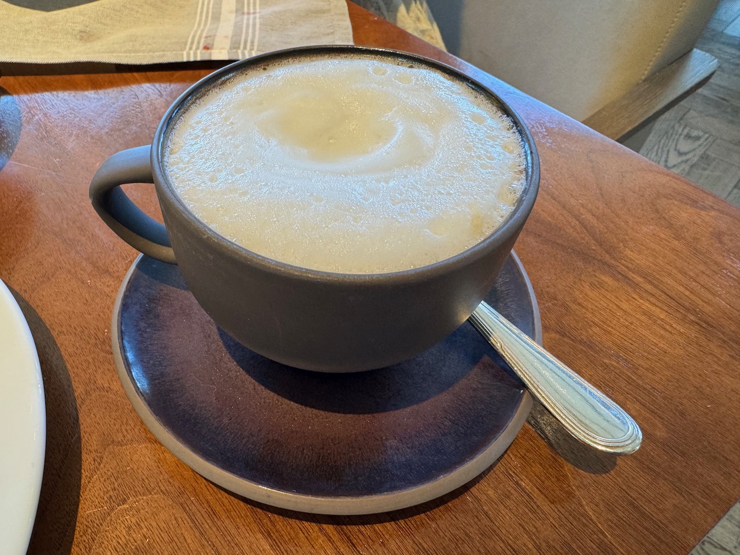 a cup of coffee with a spoon on a saucer