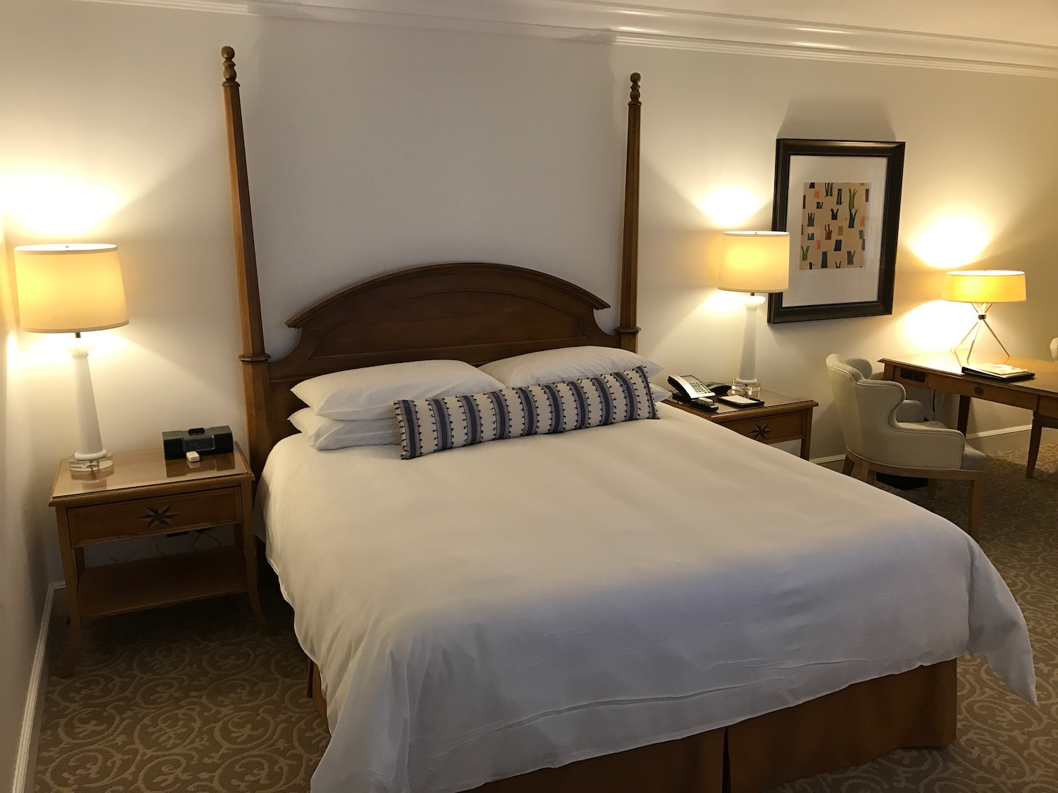 a bed with a wood headboard and two lamps