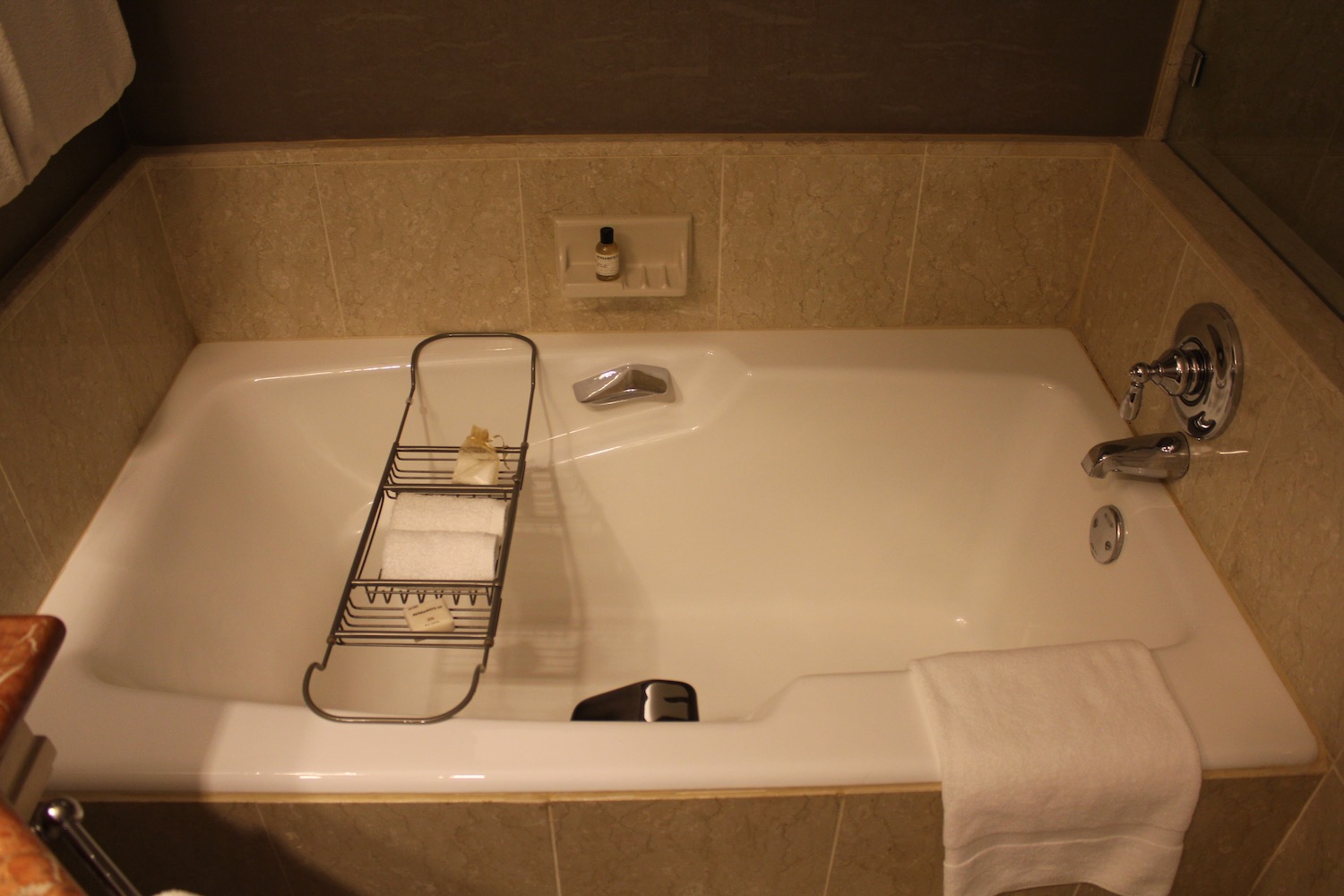 a bathtub with a towel and a rack
