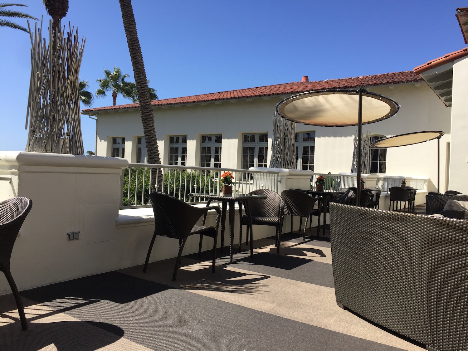 a patio with chairs and umbrellas