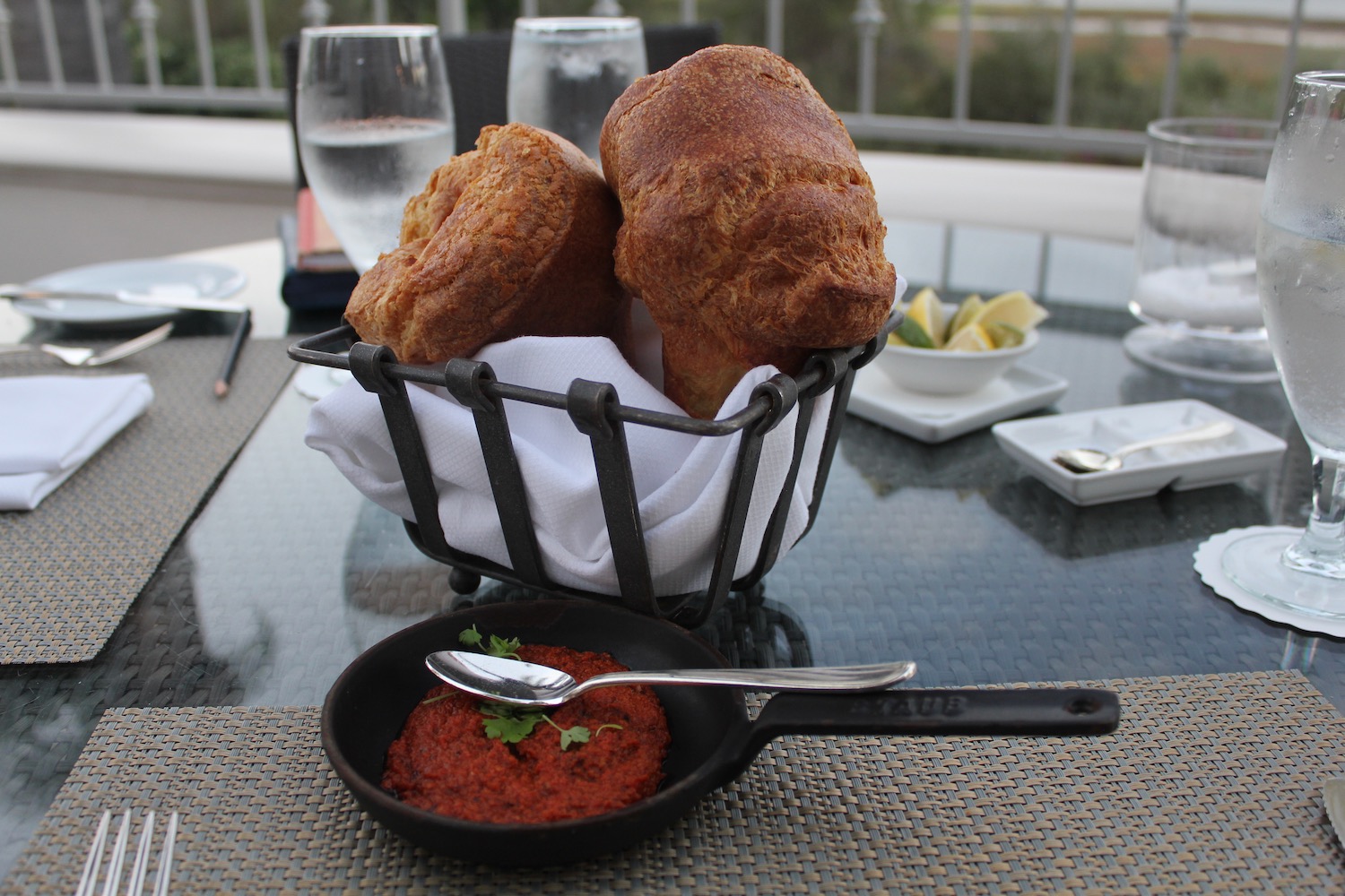 a basket of bread and sauce on a table