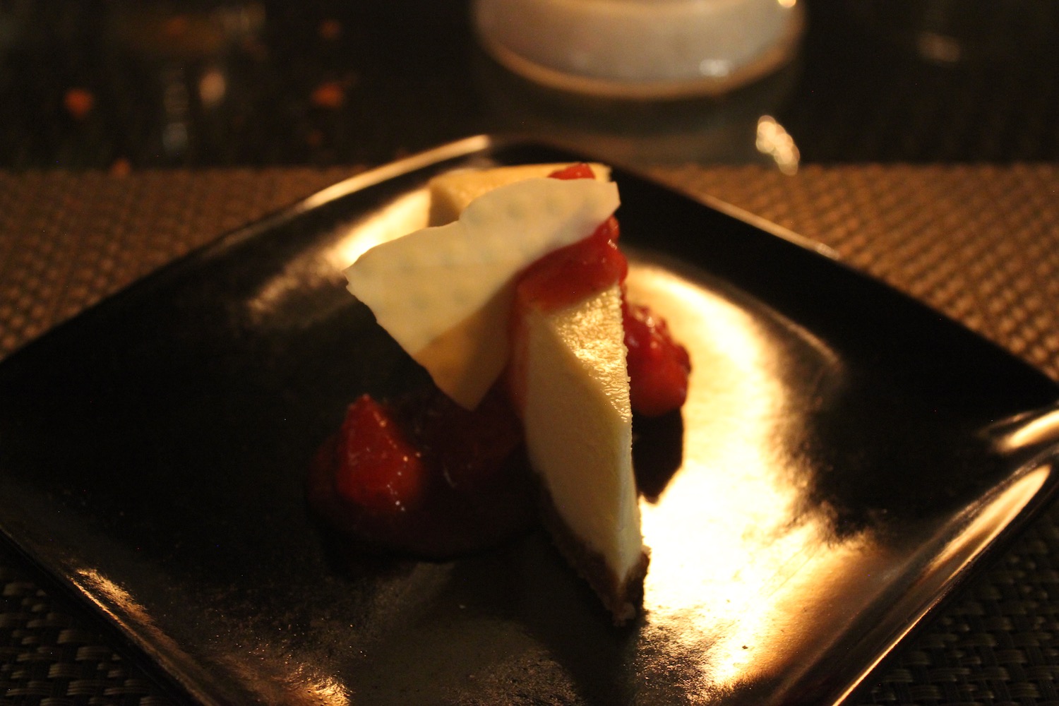 a slice of cheesecake on a black plate