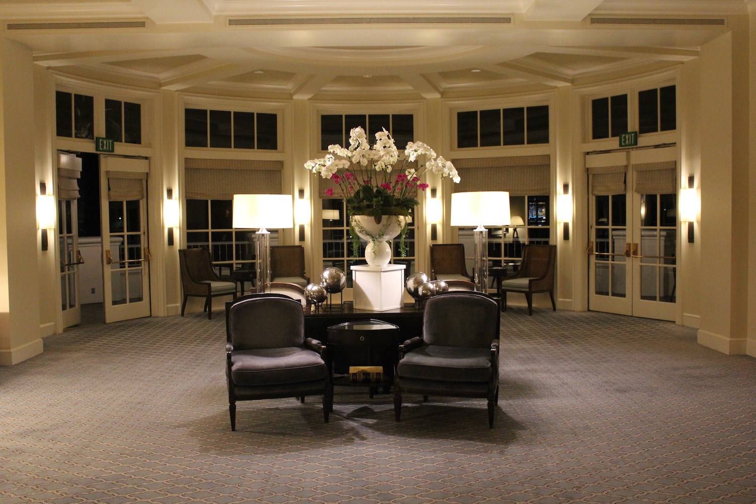 a room with chairs and a vase of flowers