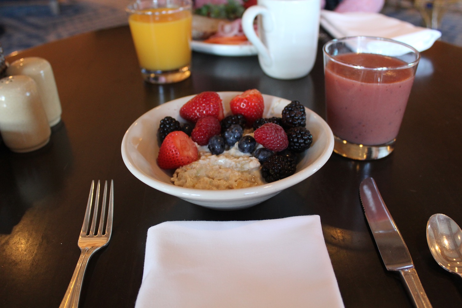 a bowl of fruit and a drink on a table