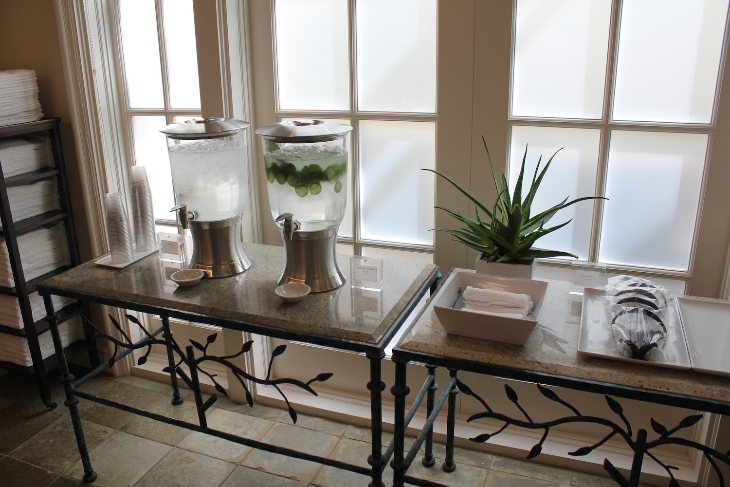 a table with two large containers of water and a plant