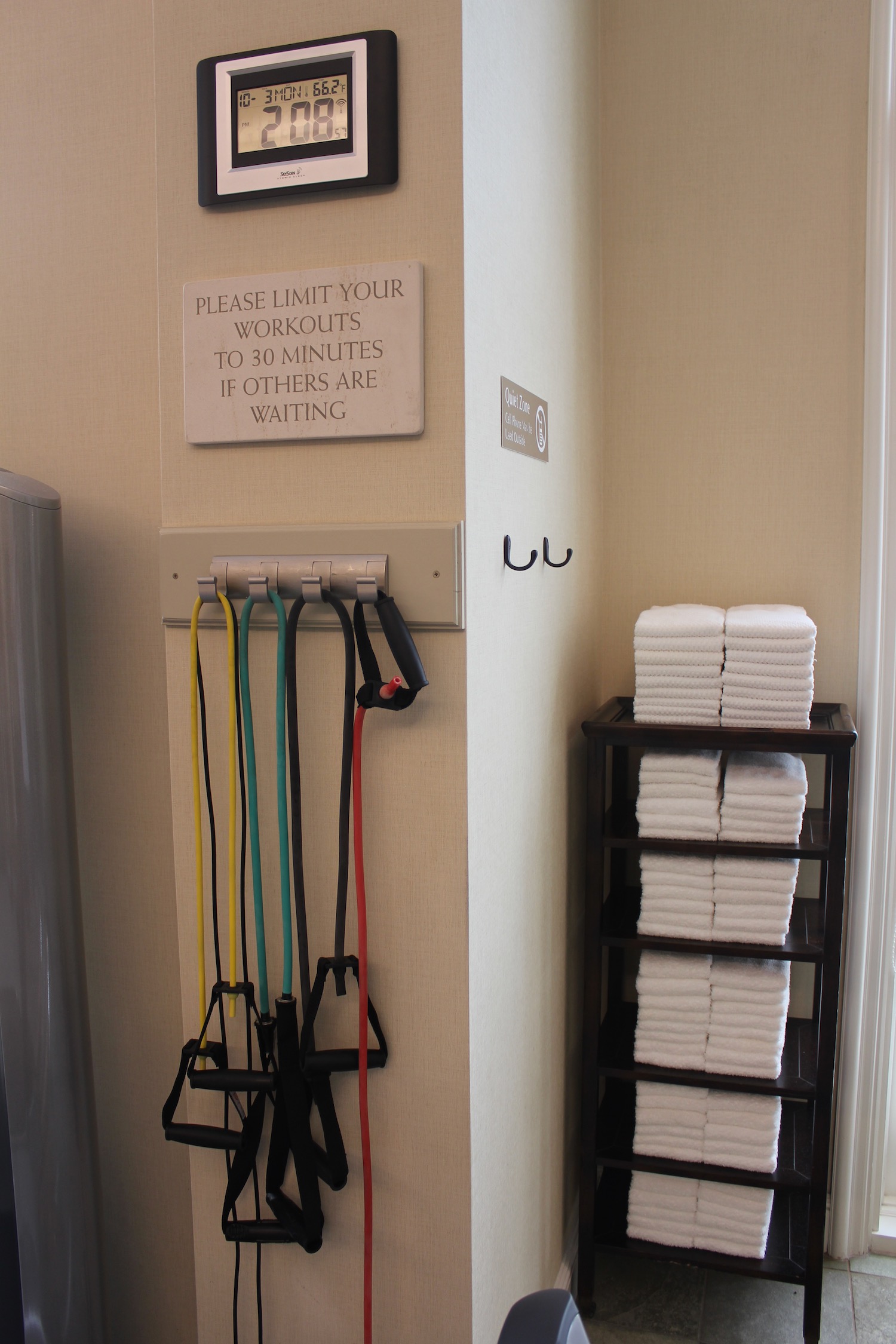 a room with a sign and a rack of white towels