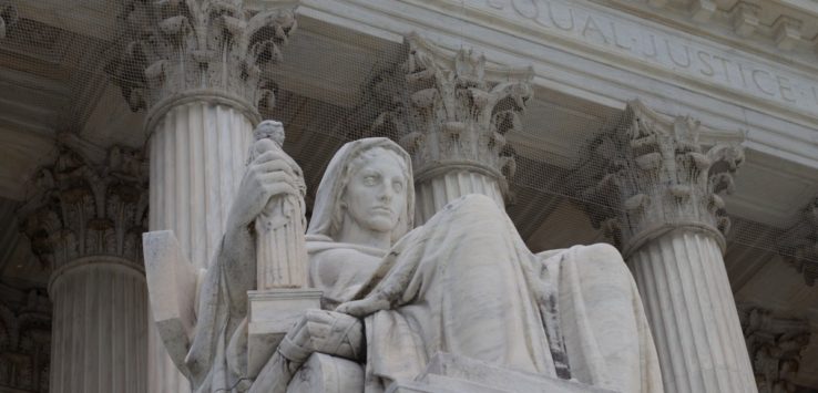 a statue of a woman sitting on a pillar