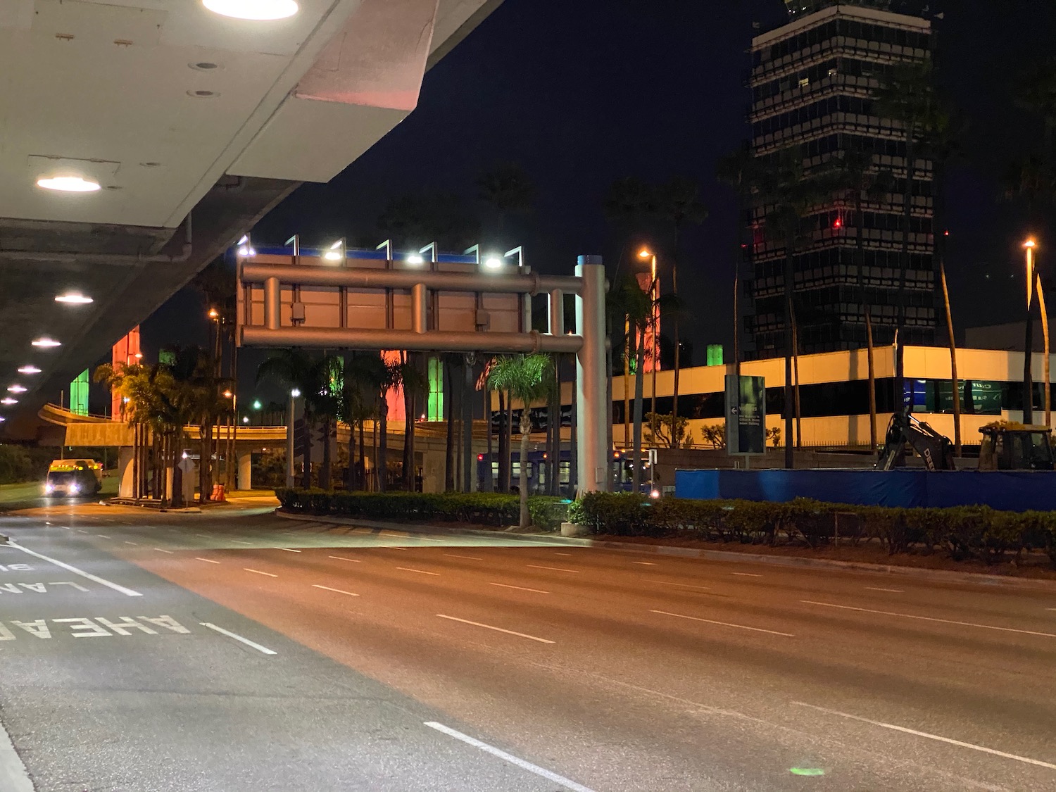 a street with a sign and palm trees