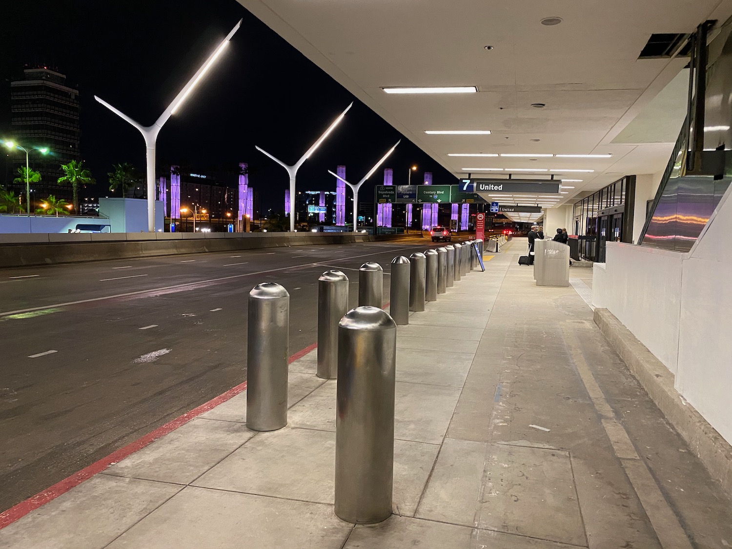 a row of silver poles on a sidewalk