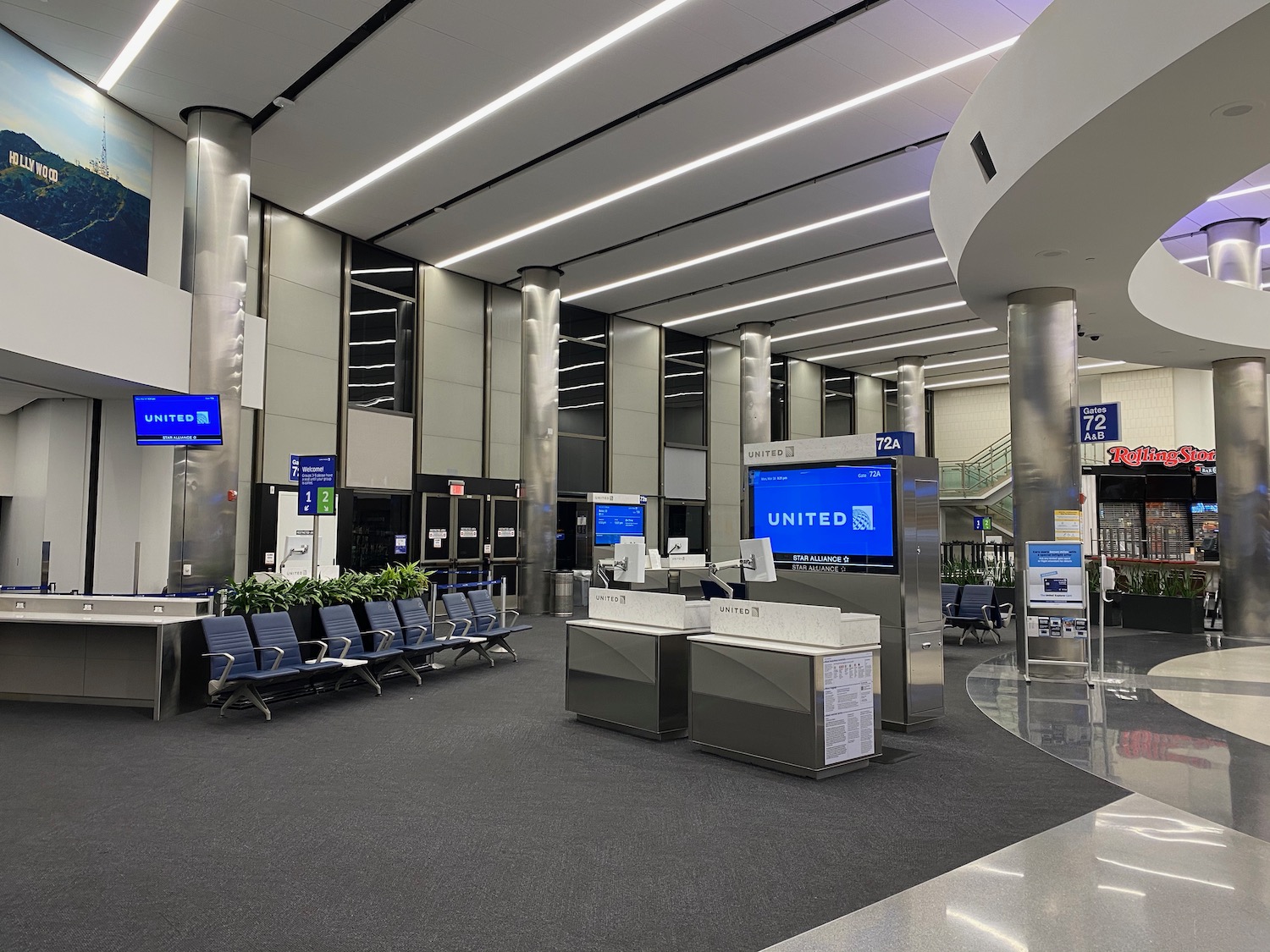 an airport terminal with blue signs and blue screens