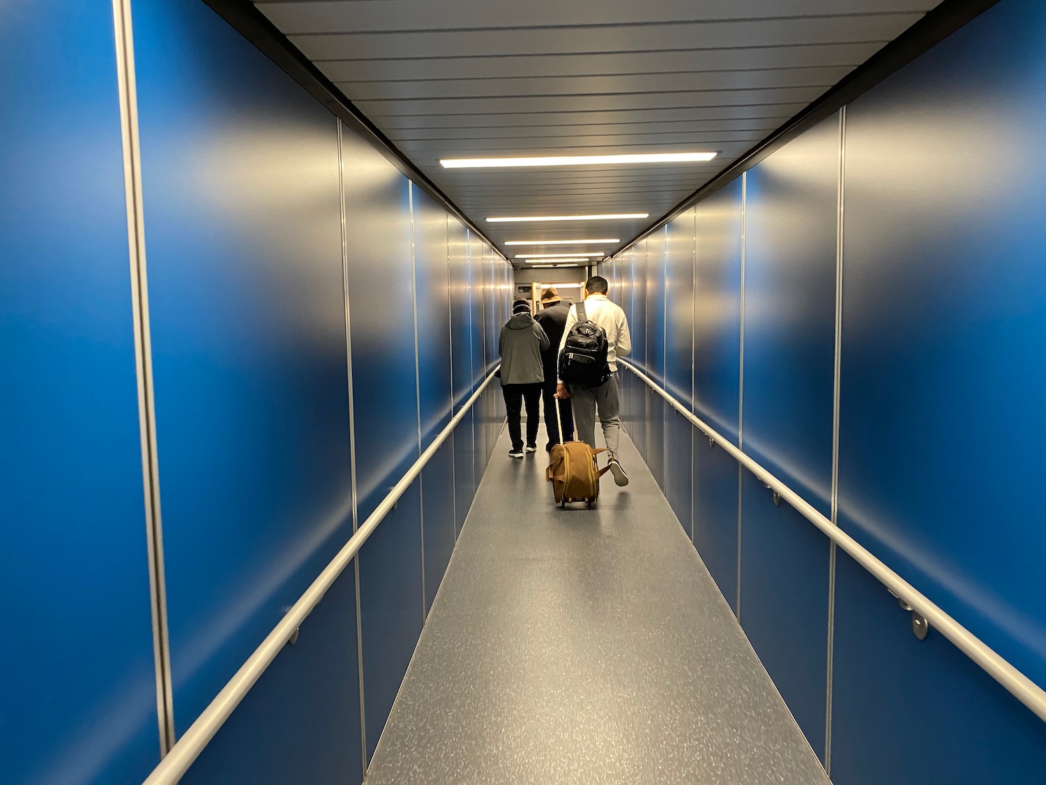 people walking down a hallway with blue walls