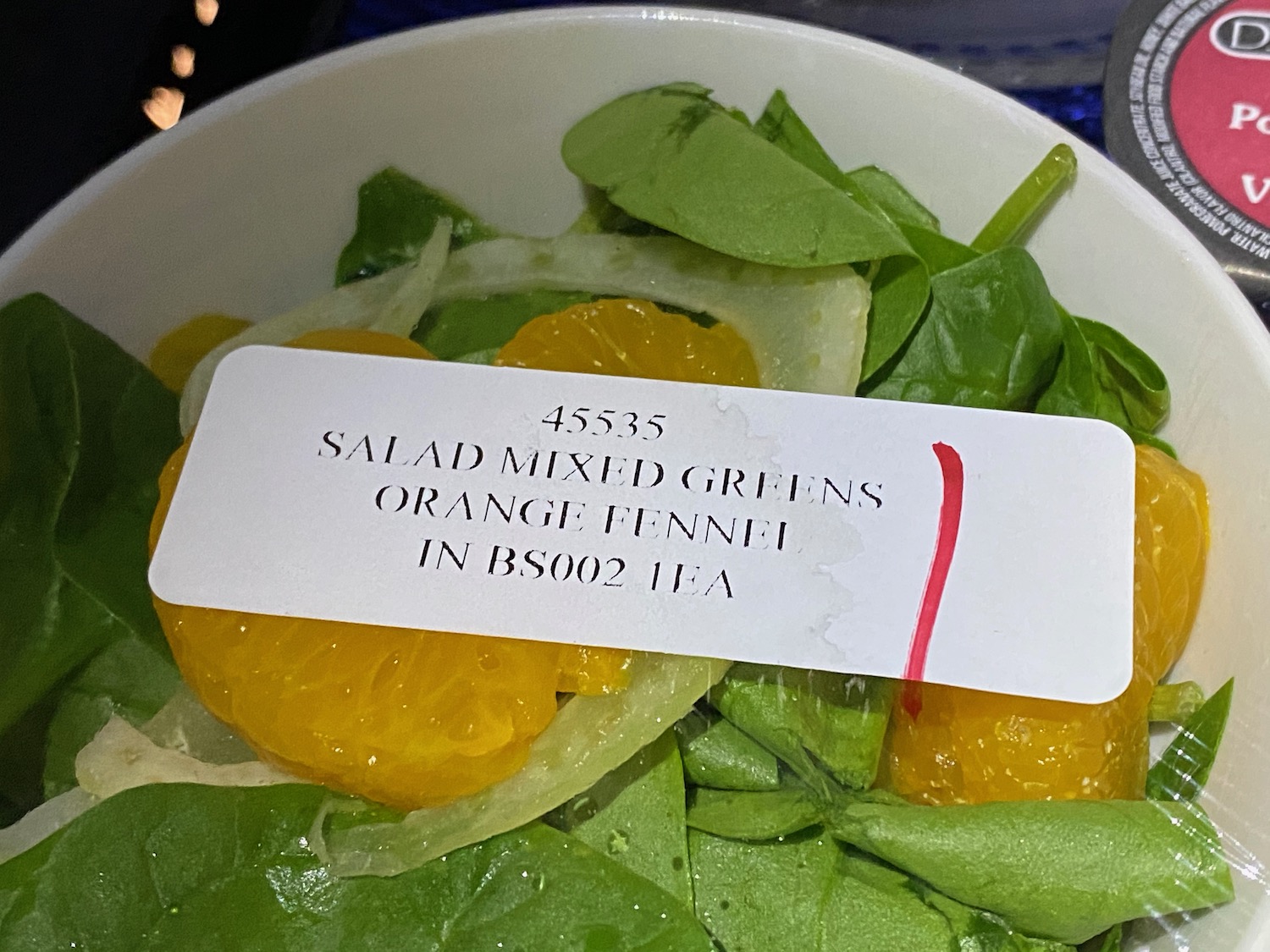 a bowl of salad with a white label