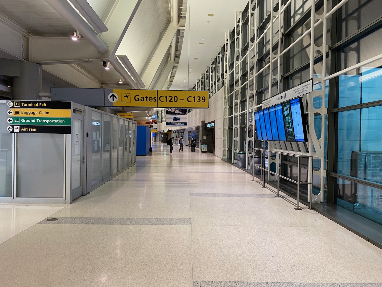a large airport hallway with a sign and people walking