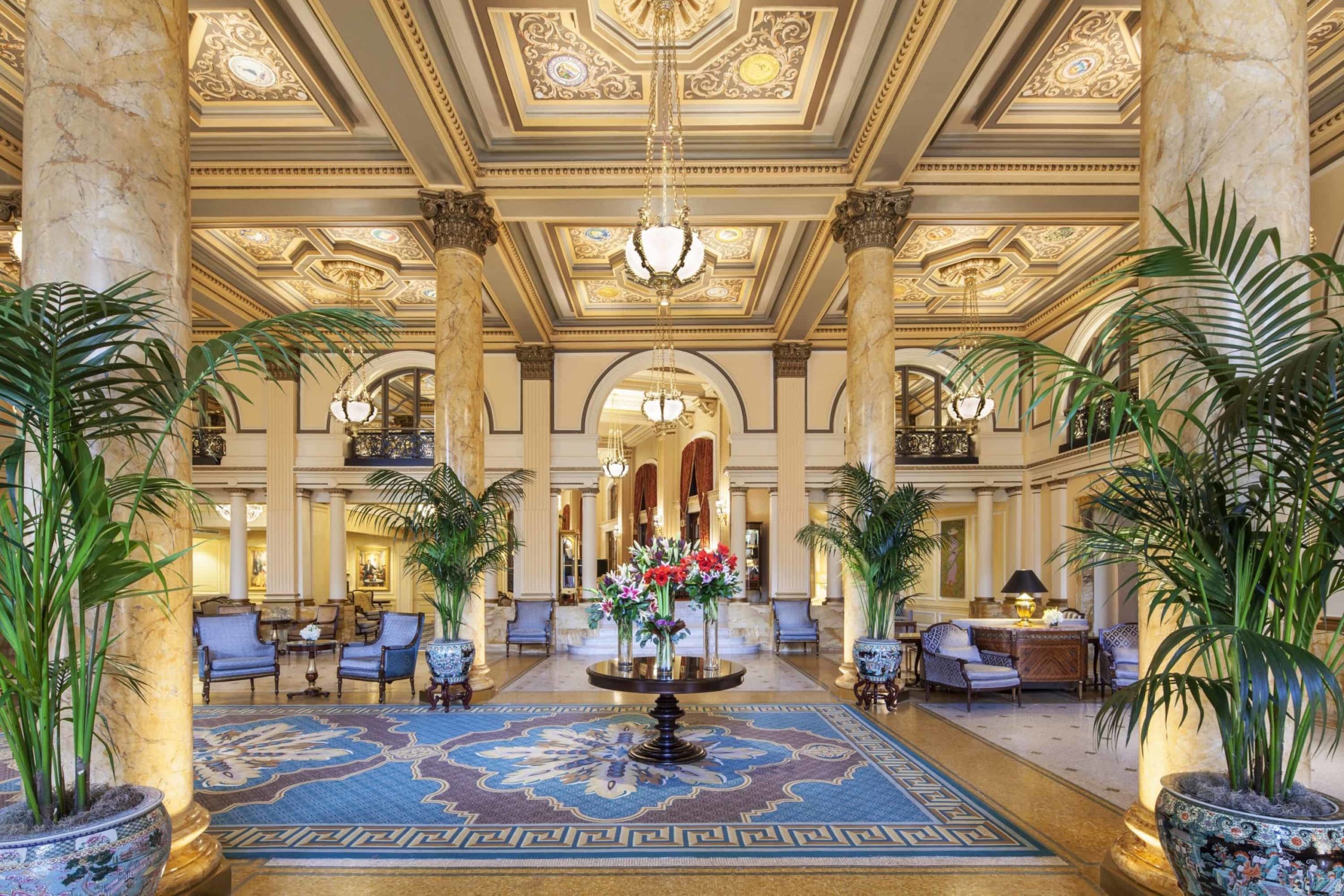 a lobby with a large rug and chairs