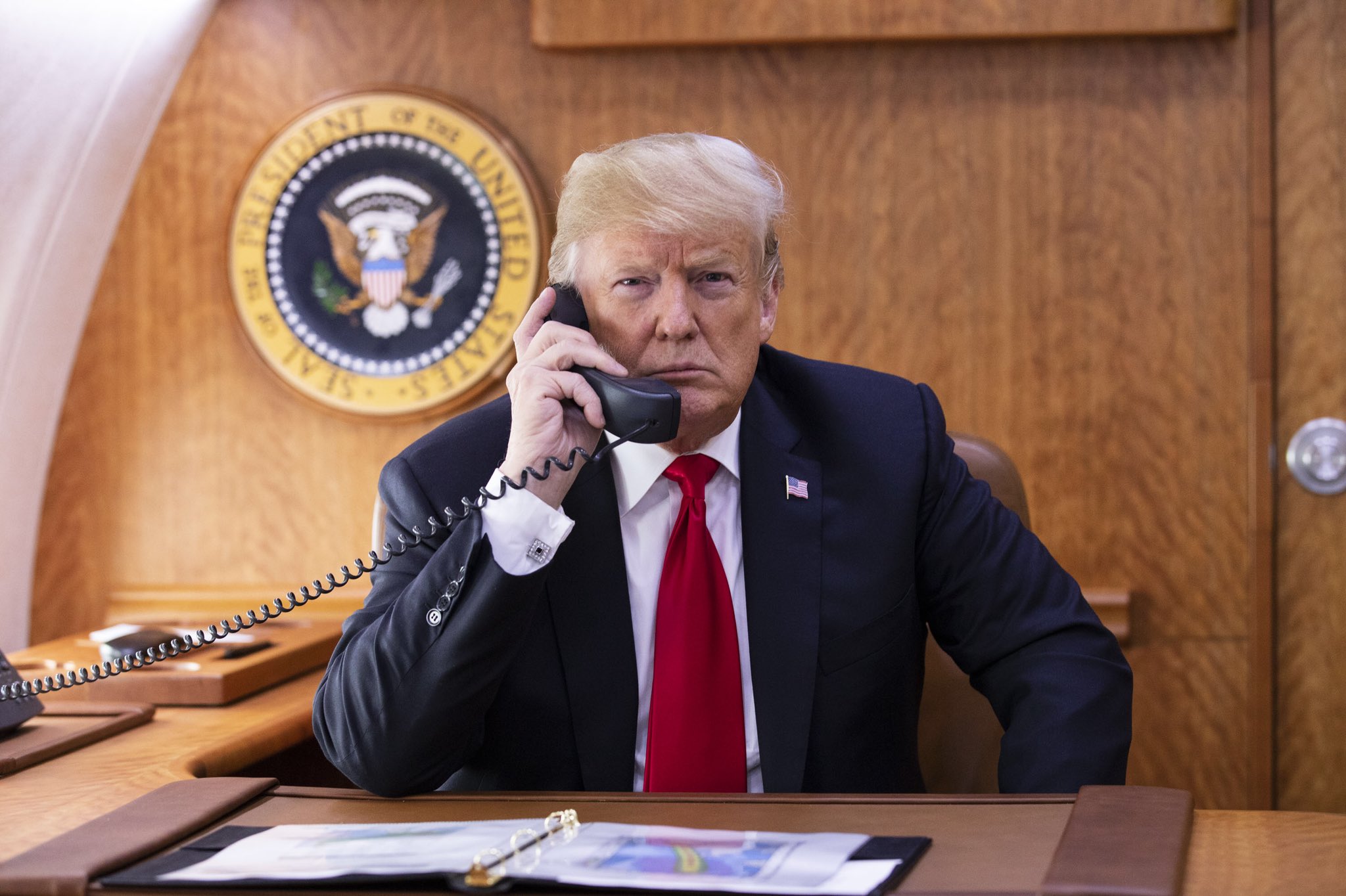 a man in a suit and tie talking on a phone