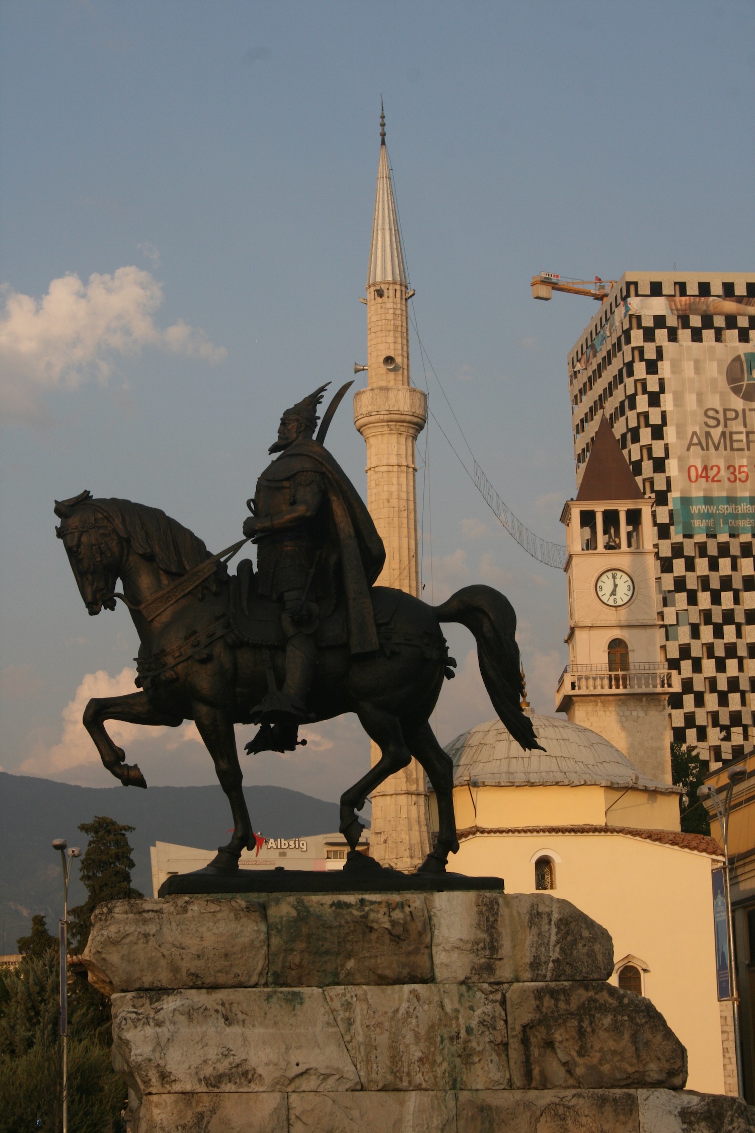 a statue of a man on a horse in front of a tall building