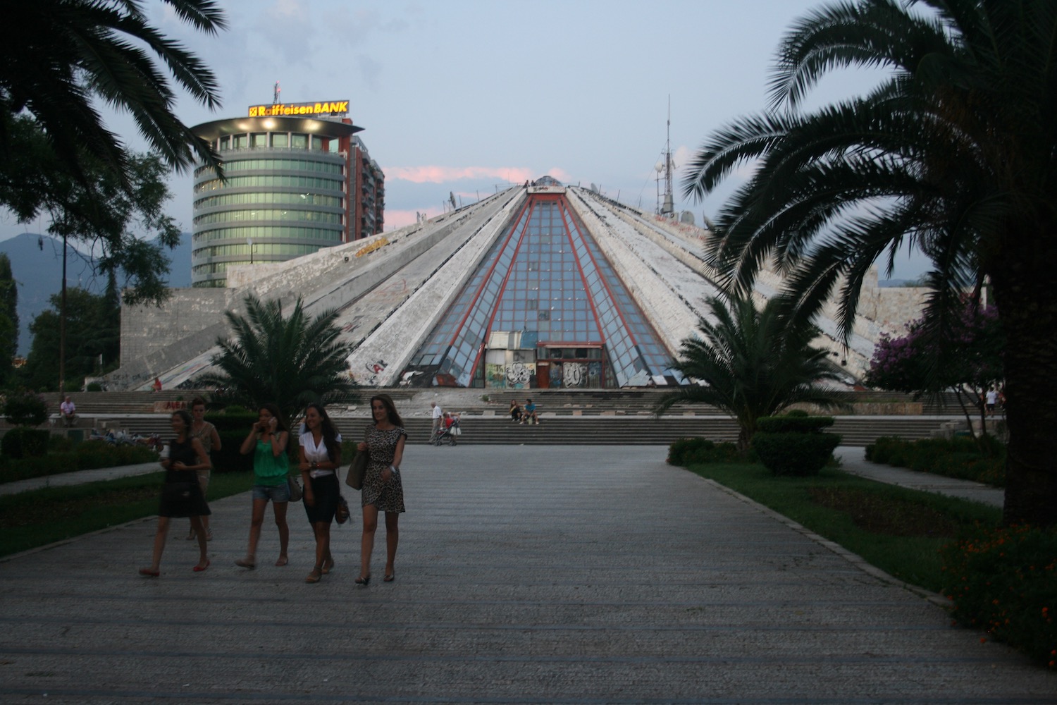 a group of people standing in front of a pyramid shaped building