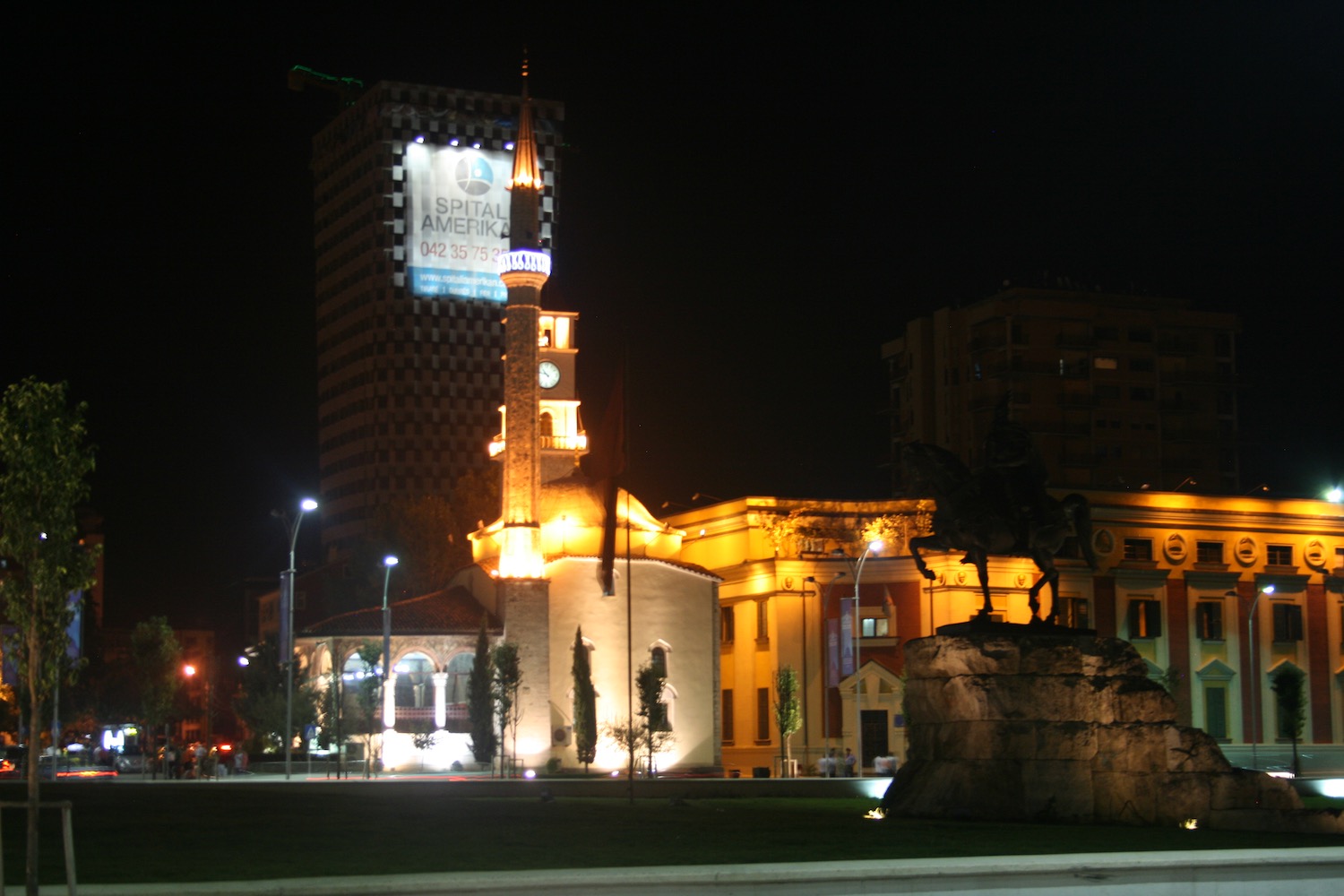 a statue of a horse and a clock tower in a city