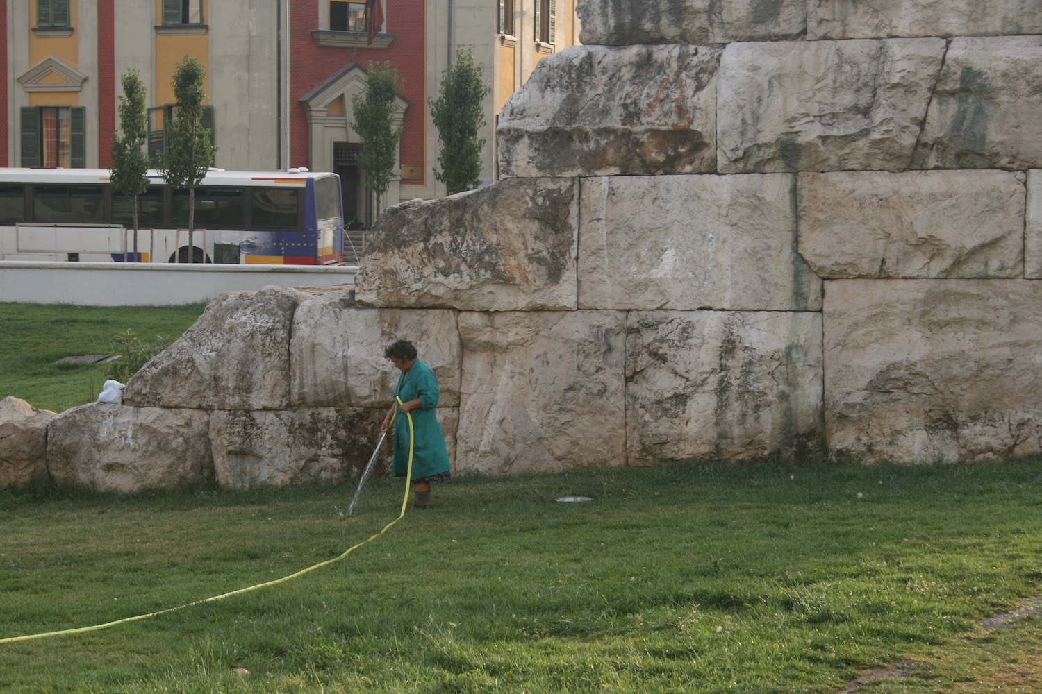 a woman watering grass with a hose