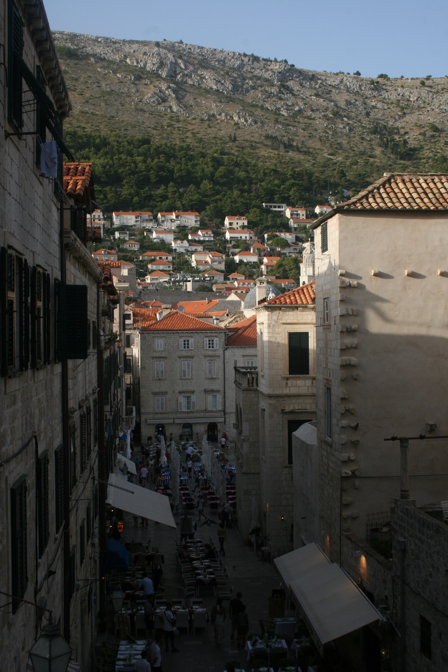 a street between buildings with a hill in the background