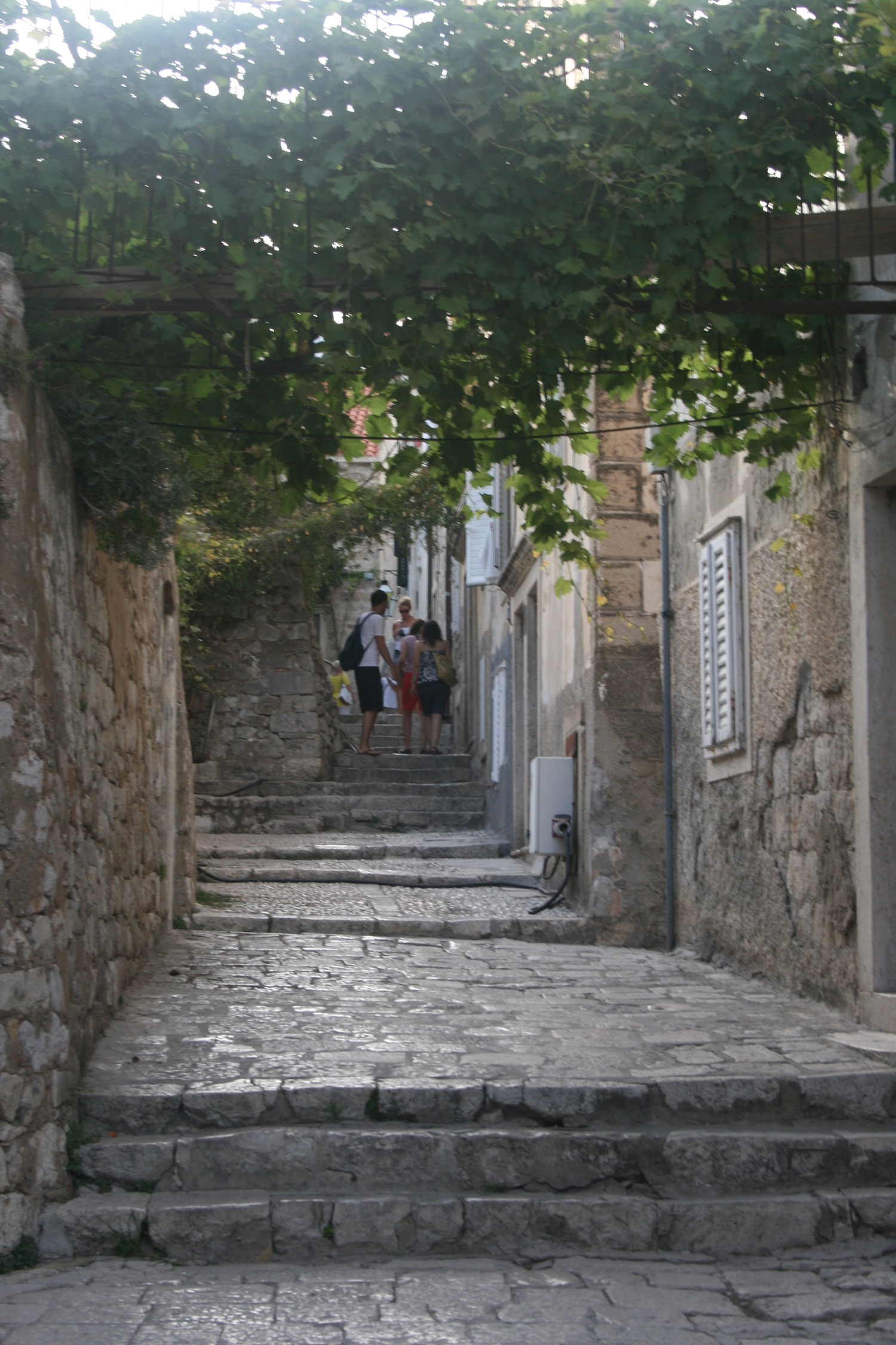 people walking down a stone alley