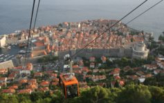 a cable car with a city in the background