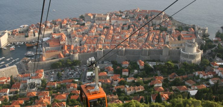 a cable car with a city in the background