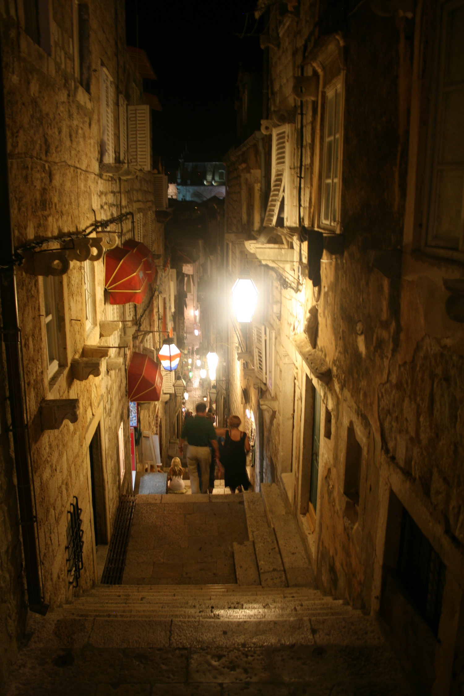 people walking down a narrow alley