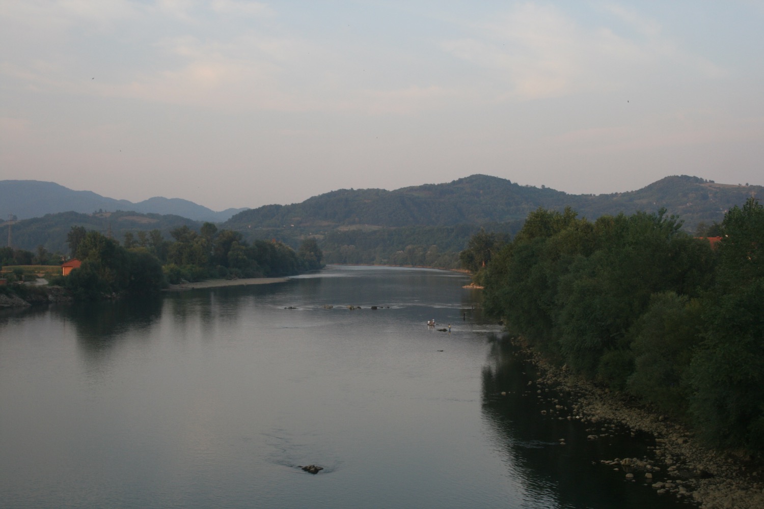 a river with trees and mountains in the background