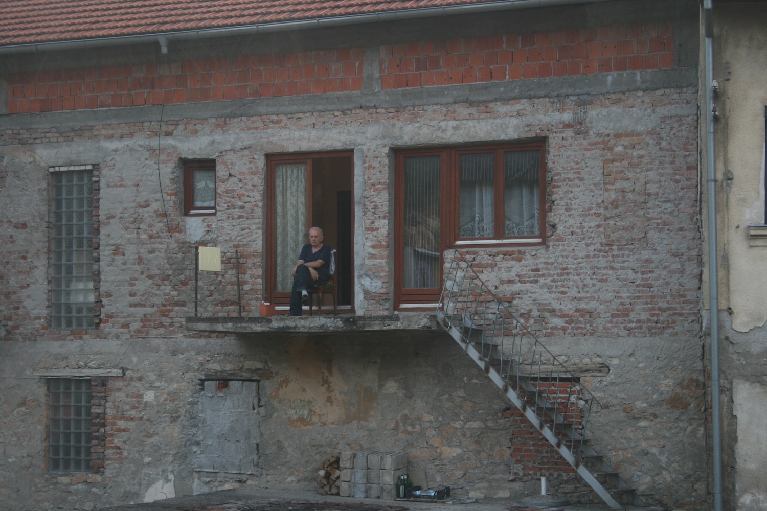 a man sitting on a balcony