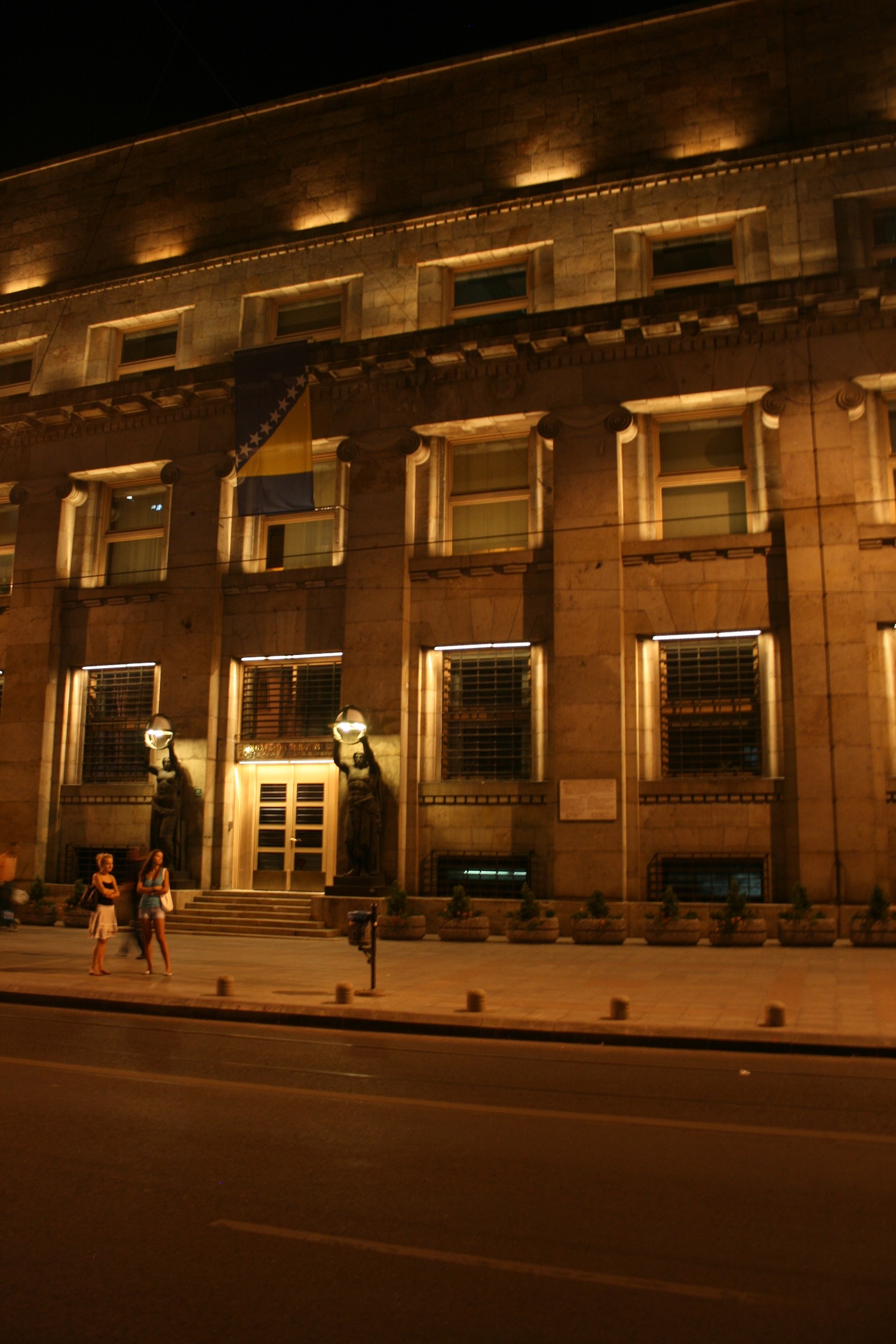 people walking on a sidewalk in front of a building