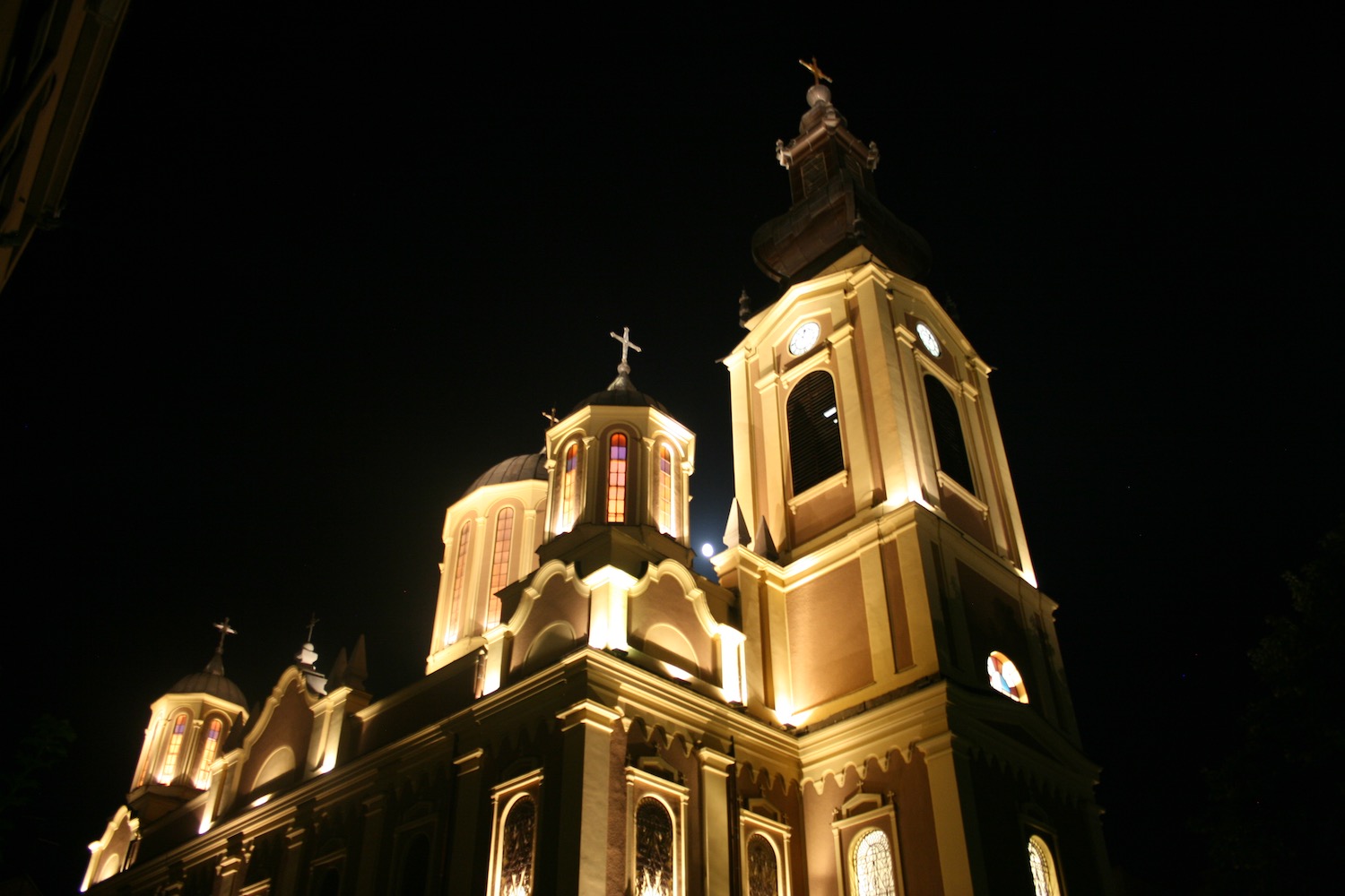 a building with a clock tower and a cross on top