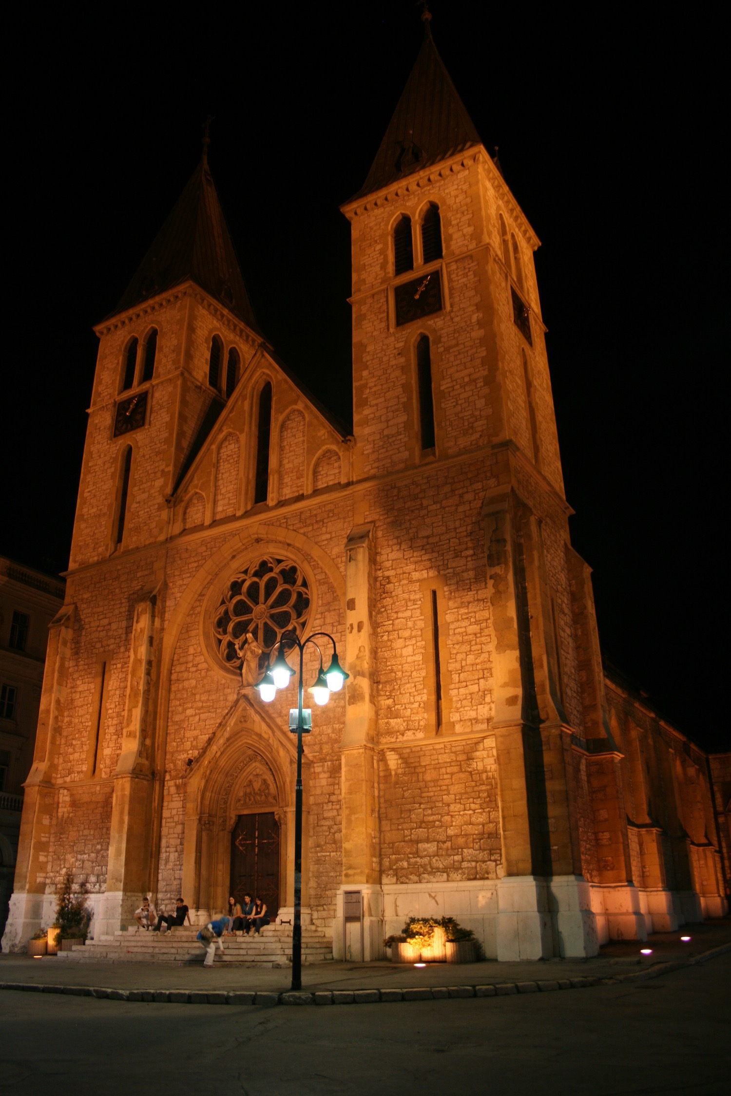 a building with a clock tower and people walking in front of it