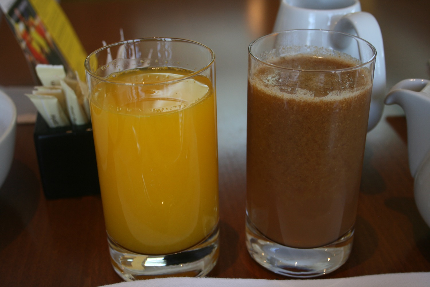 a glass of orange juice and brown liquid