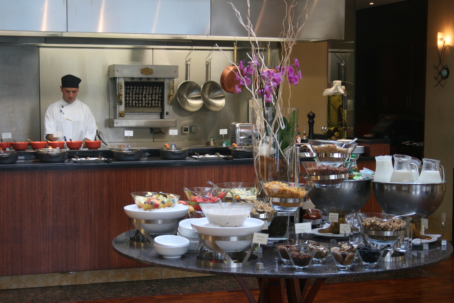 a chef in a kitchen with a table full of food