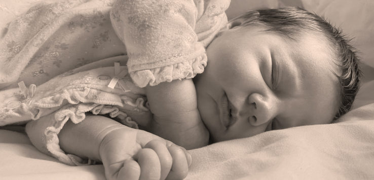 a baby sleeping on a bed