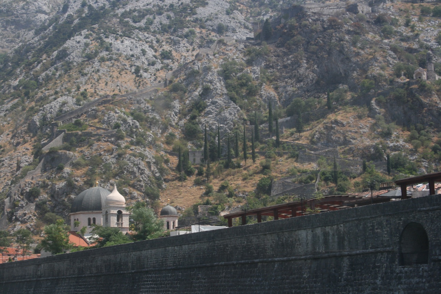 a stone wall with a building on the side