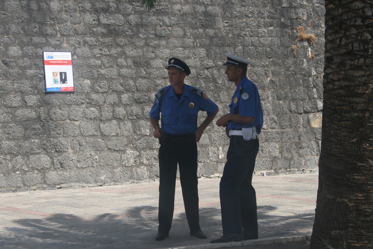 two men in uniform standing on a sidewalk
