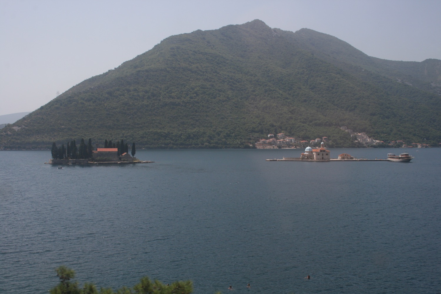 a small island in the water with a mountain in the background