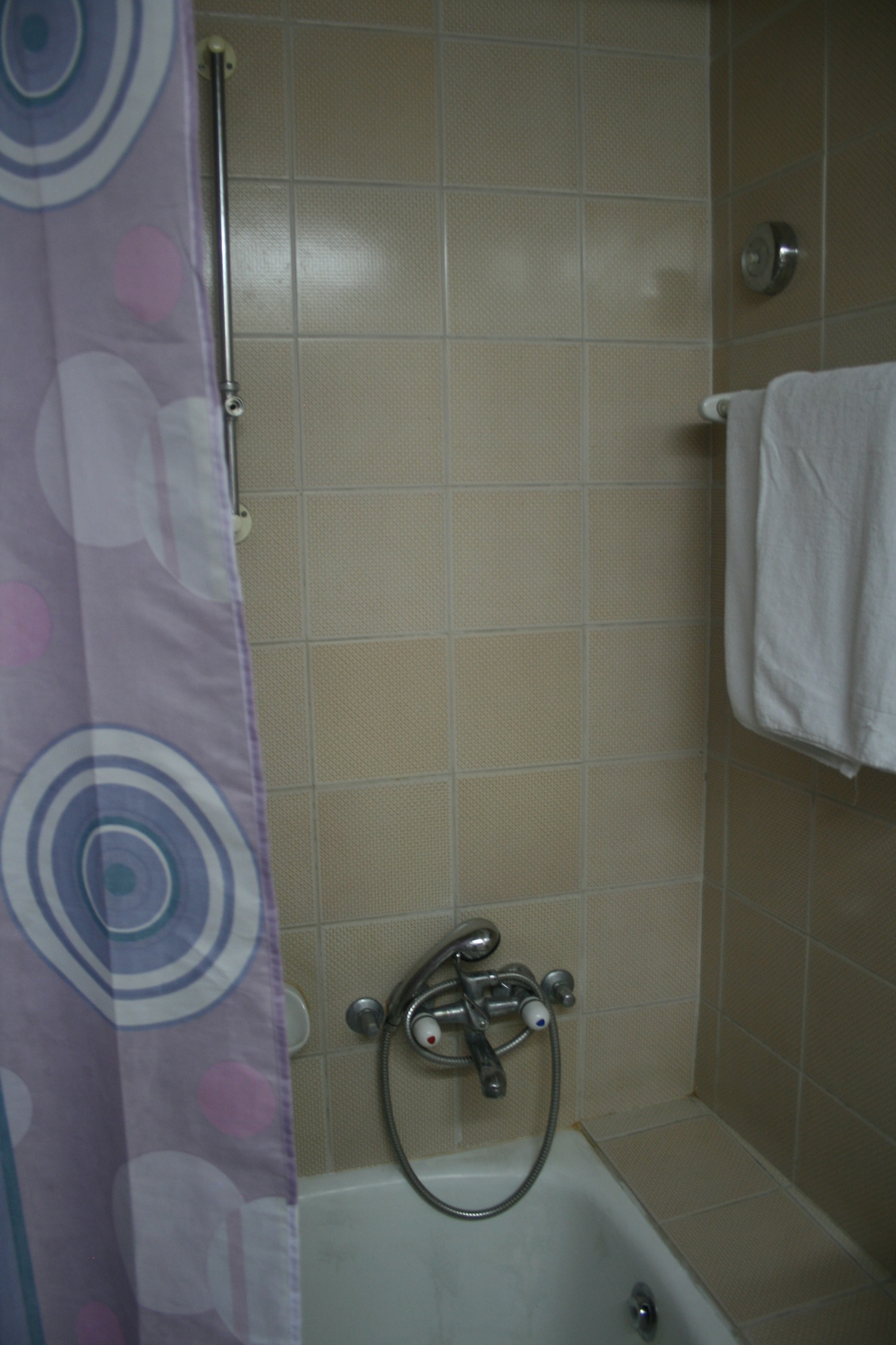 a shower with a purple shower curtain and a purple shower curtain